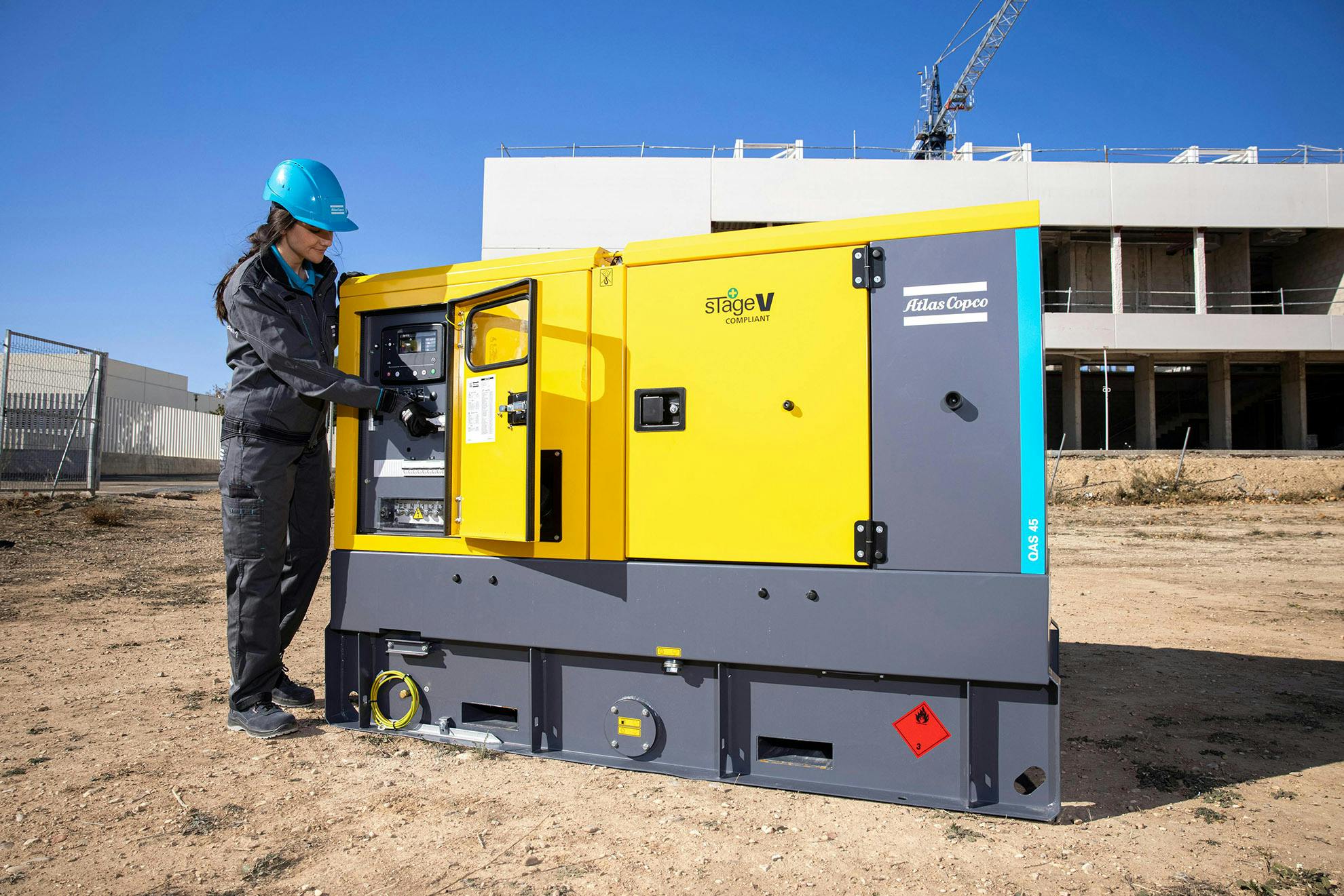 Tekniker som starter opp en QAS stageV generator på byggeplass, generator er EURO Stage V klassifisert.